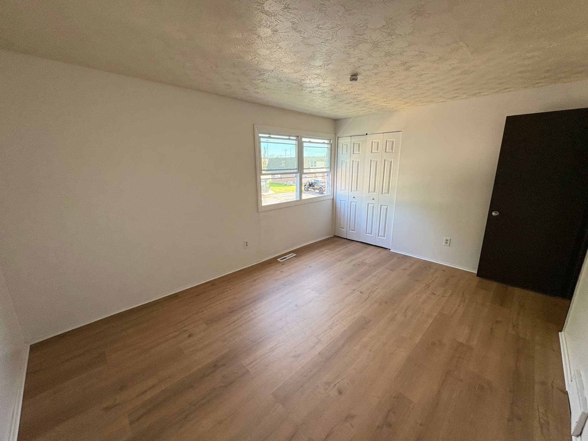 Bedroom fully refreshed with new flooring, smooth painted walls and clean modern trim