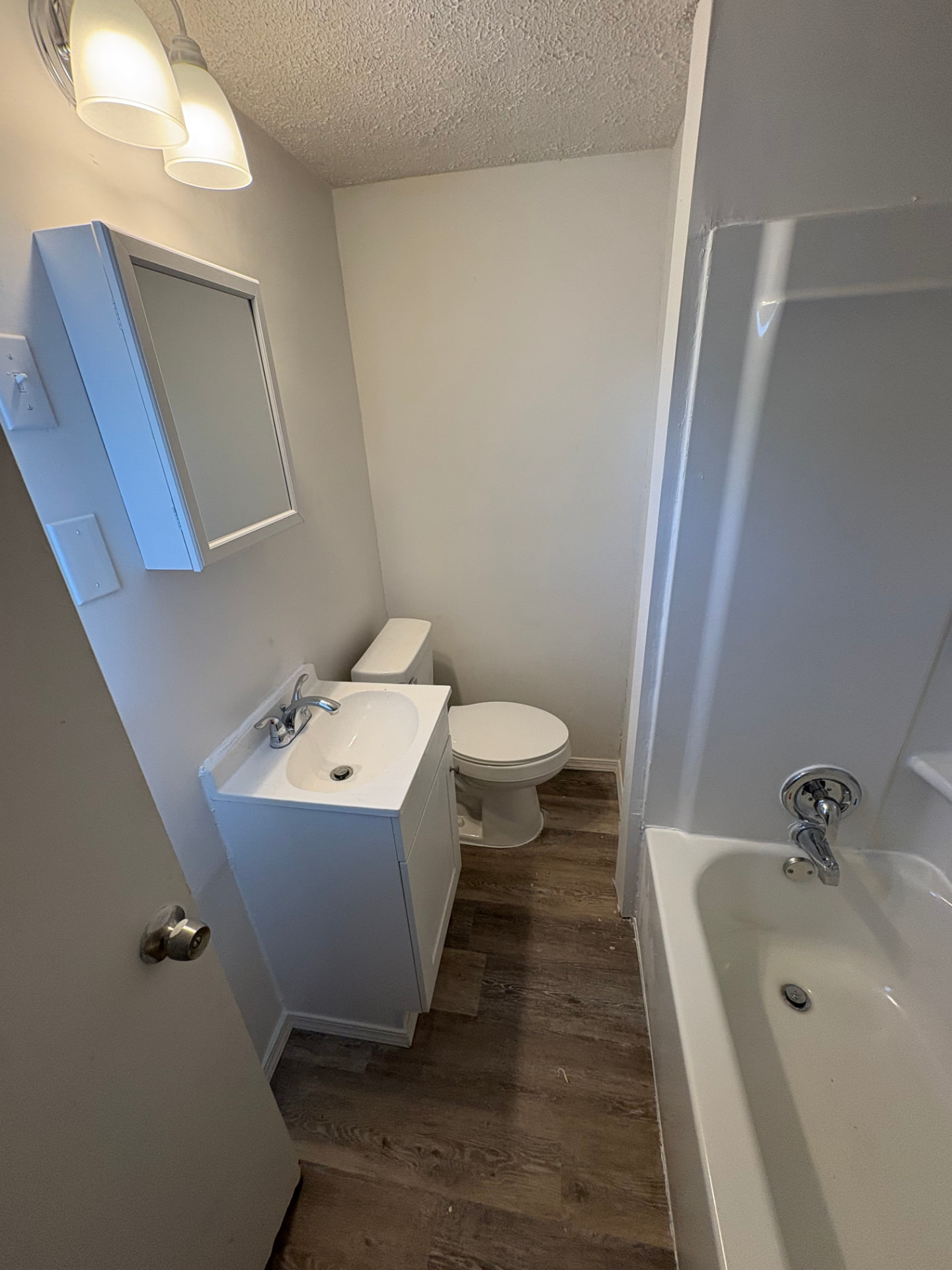 Bathroom fully remodeled with new vanity, tub, fixtures, flooring, and fresh paint