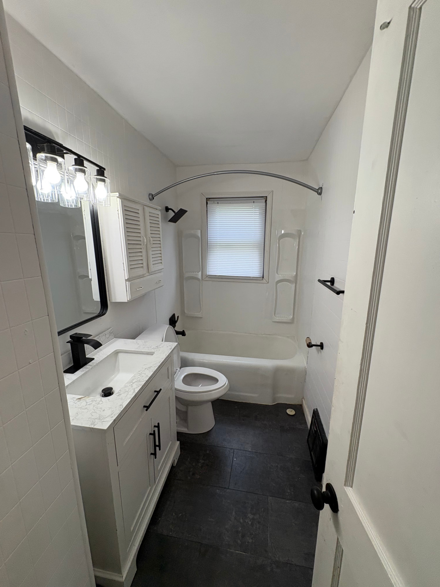 Bathroom refreshed with clean white paint, polished fixtures and bright updated finish after paint and deep cleaning