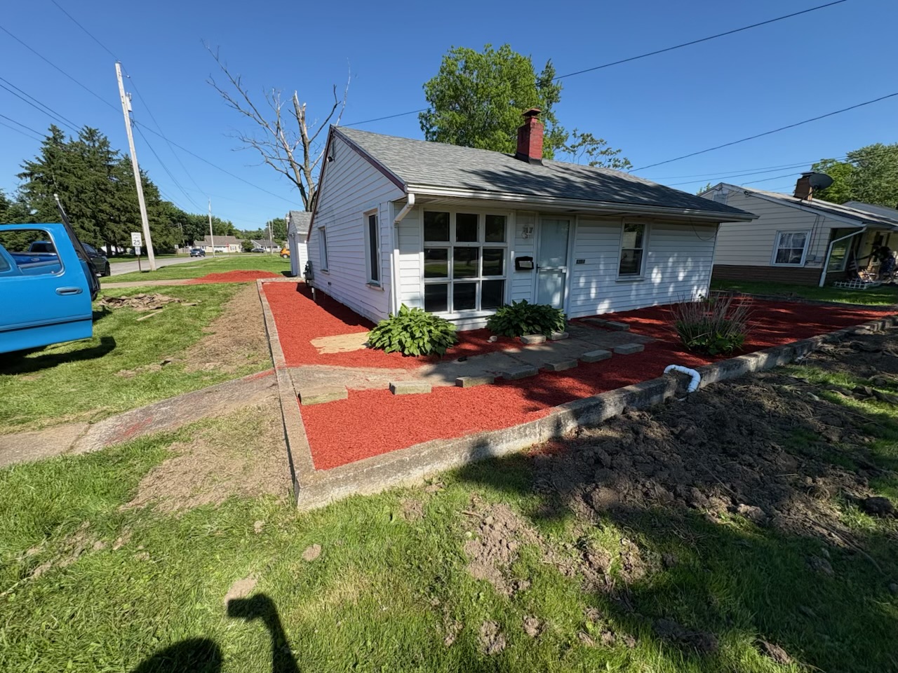 Fresh red mulch beds and cleaned walkway along the front of the house