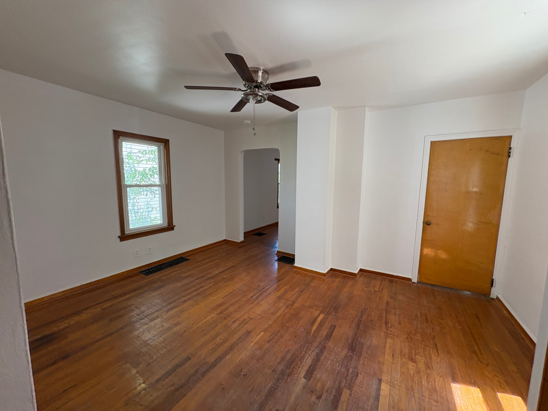 Same living room with ceiling fully repaired, smooth drywall, fresh paint, and a clean finished look